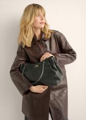 Skórzana torebka shopper w kolorze czarnym TORES-1360-9I(Z26), widok produktu w dłoni modelki. Widoczna połowa sylwetki.