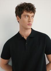 Czarna koszulka polo męska POLMT-0084-99(W26) - widok produktu z przodu, na modelu, na jasnym tle. Widoczna połowa sylwetki. 