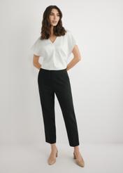 Czarne eleganckie spodnie damskie SPODT-0109-99(W26), widok produktu z przodu na modelce. Widoczna cała sylwetka.