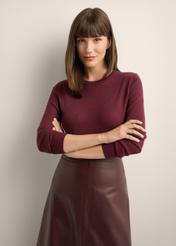 Wełniany sweter w kolorze bordowym SWEDT-0267-4D(Z26), widok produktu z przodu na modelce. Widoczna połowa sylwetki.