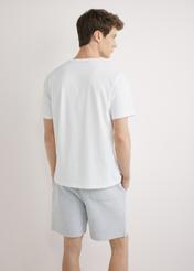 Biały T-shirt męski z nadrukiem TSHMT-0145-0A(W26), widok produktu z tyłu na modelu. Widoczna połowa sylwetki.