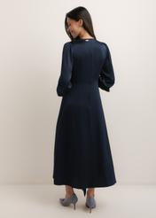 Granatowa sukienka midi SUKDT-0263-7E(W26), widok produktu od tyłu na modelce. Widoczna cała sylwetka.