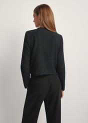 Czarna krótka marynarka damska ZAKDT-0041-99(W26), widok produktu z tyłu na modelce. Widoczna połowa sylwetki.