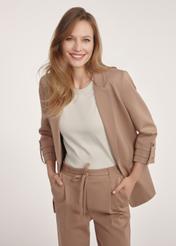 Camelowa marynarka damska bez zapięcia  ZAKDT-0034-24(Z24) - widok produktu z przodu na modelce na białym tle. Widoczna połowa sylwetki.