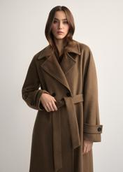 Wełniany płaszcz damski camelowy PLADT-0061-24(Z25) - widok produktu z przodu, na modelce, na jasnym tle. Widoczna połowa sylwetki.