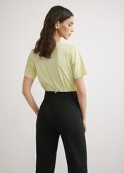 Jasnożółty T-shirt damski basic TSHDT-0120-2A(W26), widok produktu z tyłu na modelce. Widoczna połowa sylwetki.