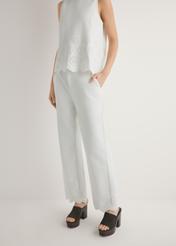 Białe spodnie damskie wide leg SPODT-0122-0B(W26), widok produktu z przodu na modelce. Widoczna połowa sylwetki.