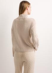 Damski sweter oversize w jasnobeżowym kolorze SWEDT-0278-1A(Z26), widok produktu od tyłu na modelce. Widoczna połowa sylwetki.