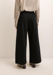 Czarne spodnie damskie wide leg SPODT-0130-99(Z26), widok produktu z tyłu na modelce. Widoczna połowa sylwetki.