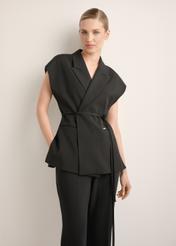 Czarna kamizelka garniturowa damska oversize KAMDT-0039-99(Z26), widok produktu z przodu na modelce. Widoczna połowa sylwetki.