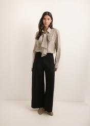 Czarne spodnie damskie wide leg SPODT-0130-99(Z26), widok produktu z przodu na modelce. Widoczna cała sylwetka.