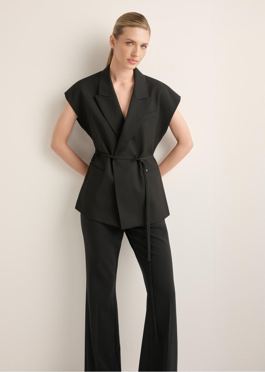 Czarna kamizelka garniturowa damska oversize KAMDT-0039-99(Z26), widok produktu z przodu na modelce. Widoczna cała sylwetka.