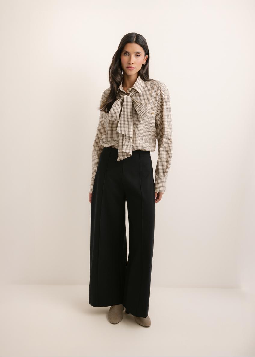 Czarne spodnie damskie wide leg SPODT-0130-99(Z26), widok produktu z przodu na modelce. Widoczna cała sylwetka.